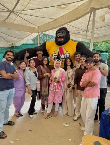 Students at a university in Karachi pose with a performer in a gorilla costume | Photo courtesy the writer