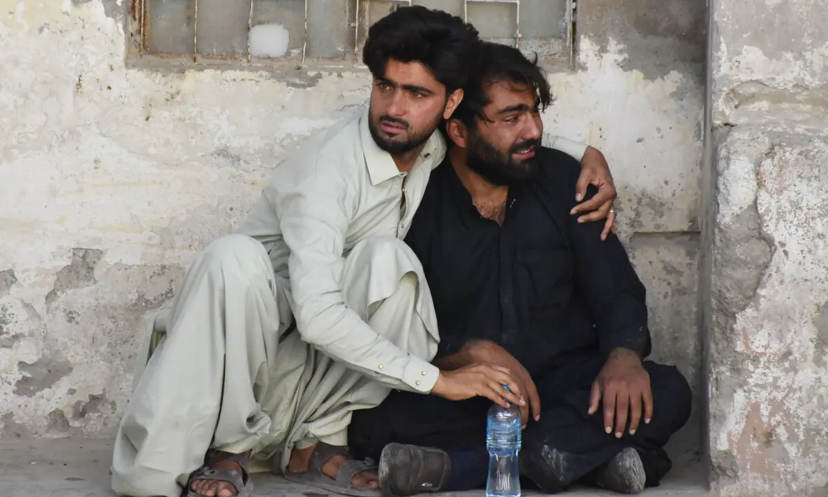 A man comforts a relative of a victim at a hospital after an explosion targeted a train in Quetta on May 24, 2026. โ AFP