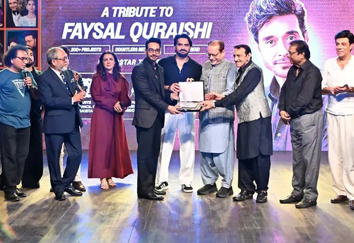 Actor Faysal Quraishi is presented with a memento at event.—Dawn