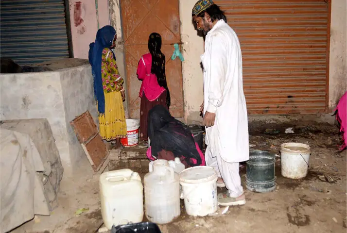 PEOPLE fetch drinking water from an underground tank in a Hyderabad locality amid persisting crisis on Tuesday.—Dawn