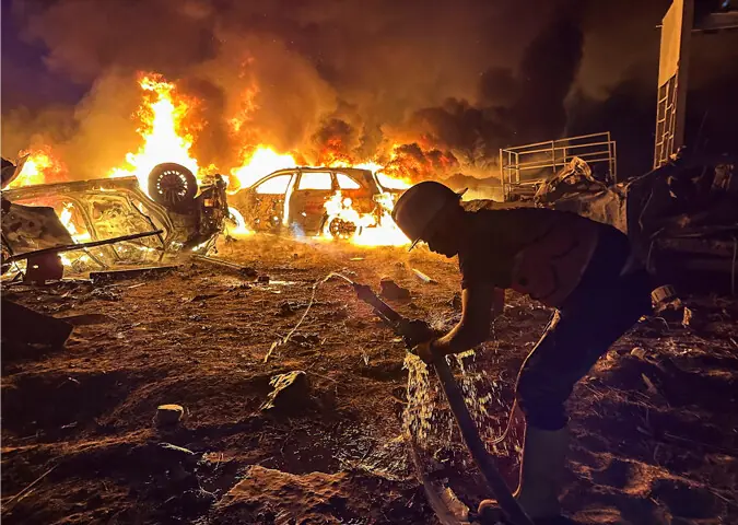 KHAN YUNIS: A civil defence worker attempts to extinguish a fire following an Israeli strike on a warehouse.&mdash;Reuters