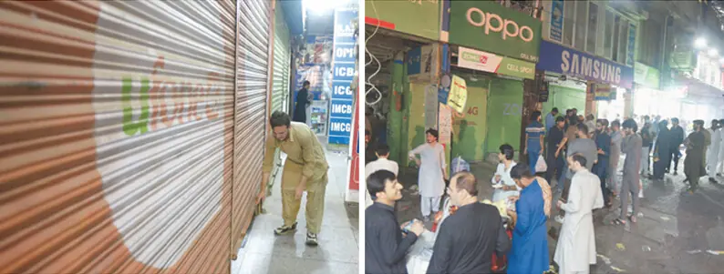  A shopkeeper pulls down a shutter while traders stand outside their shops at Aabpara Market in Islamabad on Monday after the district administration ordered markets, shopping malls and other businesses to close by 8pm. &mdash; Photos by Mohammad Asim 