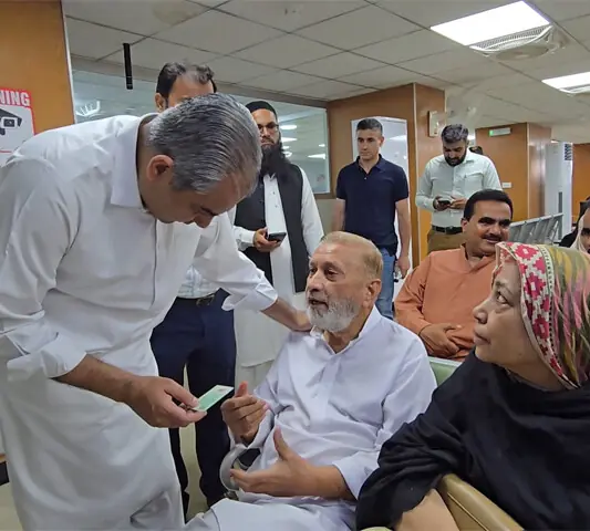 Interior Minister Mohsin Naqvi interacts with people at the centre.—Dawn
