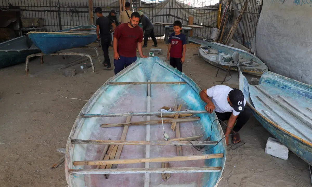 A Palestinian worker repairs a skiff damaged in the Israeli offensive, in Gaza City on June 3, 2026. —Reuters