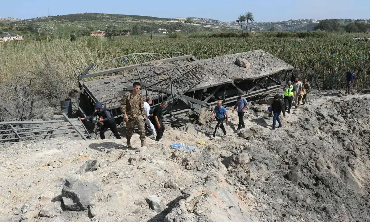 People cross on foot the Qasmieh bridge, the last bridge between the southern Lebanese cities of Tyre and Sidon regions, after it was targeted by an Israeli airstrike on April 16, 2026. — AFP/File