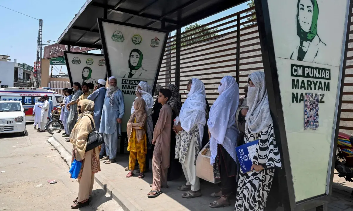 Commuters stand under a bus shelter as they wait to board an air-conditioned bus on a hot summer day in Rawalpindi on June 9, 2026. —AFP