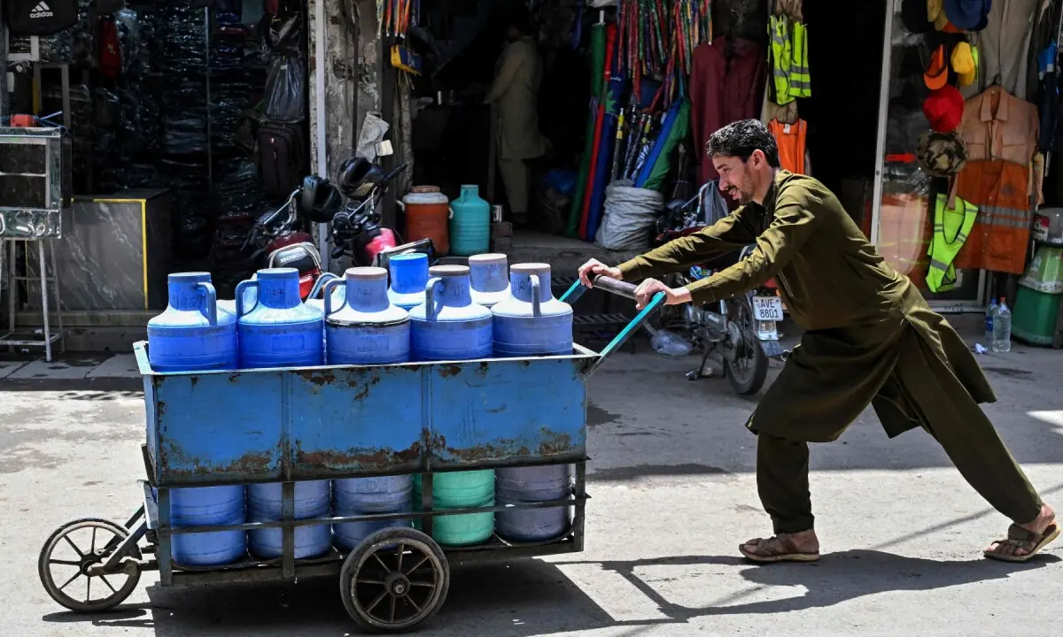 A man pushes a cart loaded with water cans on a hot summer day in Lahore on June 9, 2026. —AFP