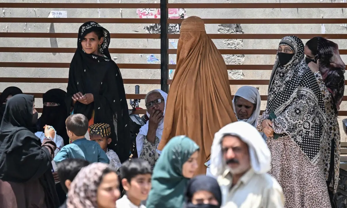 Commuters stand under a bus shelter as they wait to board an air-conditioned bus on a hot summer day in Rawalpindi on June 9, 2026. —AFP