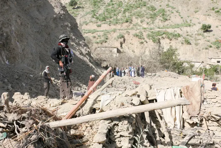 A TALIBAN security member stands on top of the debris of a house following an air strike on a village near Spera, Khost province.—Reuters