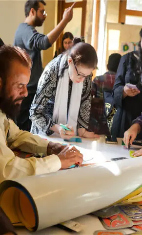 A crowd around a table during the Reading Room Festival at the Khalikdina Hall, organised by KMC and Numaish Collective | Rahat Rafiq