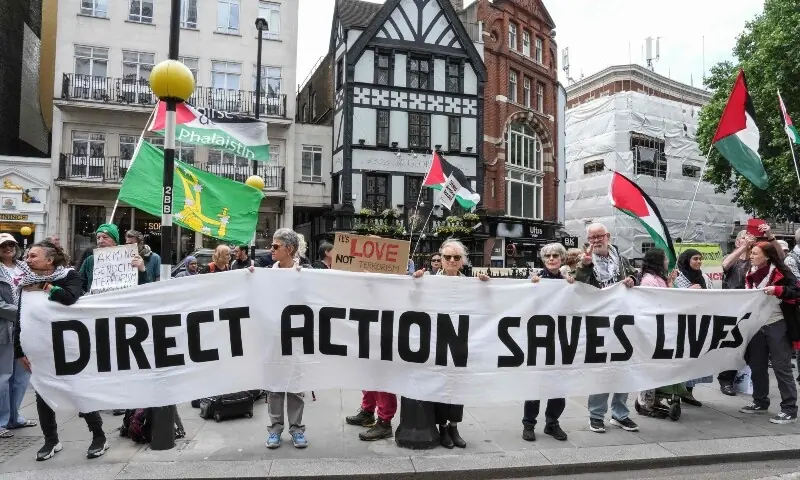 Protesters hold a banner outside the Royal Courts Of Justice in central London on June 15, 2026, as the High Court rules on a legal standoff between the government and activist group Palestine Action. —AFP