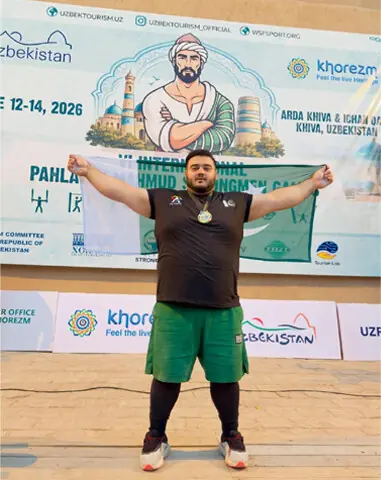 KHIVA (Uzbekistan): Pakistan’s Nooh Dastagir Butt poses with the national flag after winning gold in the Jalaluddin Sword Challenge during the Sixth International Pehalvon Mahmud Strongmen Games at the Ichan Qala Complex.