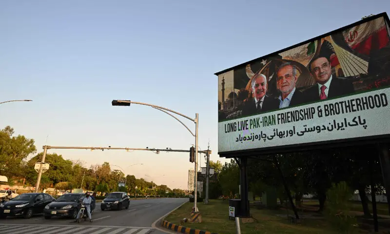  Commuters ride past an electronic board featuring Iran&rsquo;s President Masoud Pezeshkian (C), Prime Minister Shehbaz Sharif (L) and President Asif Ali Zardari (R), displayed along a road in Islamabad ahead of Pezeshkian&rsquo;s visit to Pakistan amid US-Iran peace talks on June 23. &mdash; AFP 