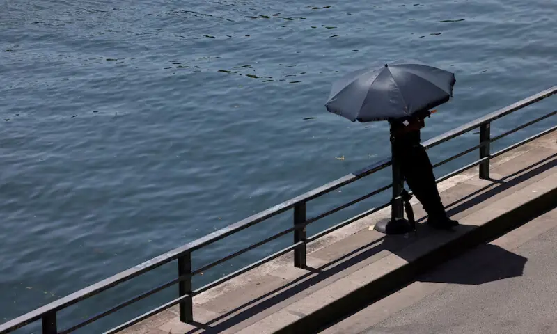 A person shelters from the sun under an umbrella along the banks of the River Seine in Paris as temperatures rise during a heatwave affecting a large part of France, June 22. — Reuters