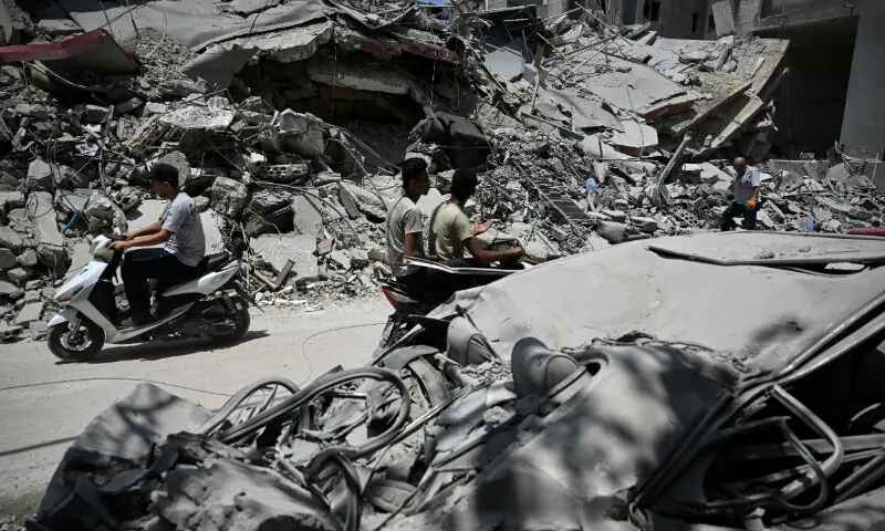  Men ride their motorbikes past the rubble of a building hit in earlier Israeli military strikes on a neighbourhood in the southern Lebanese coastal city of Tyre on June 23, 2026. &mdash; AFP 