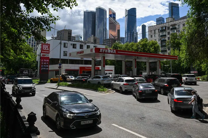  MUSCOVITES queue to refuel their cars at a petrol station.&mdash;AFP 