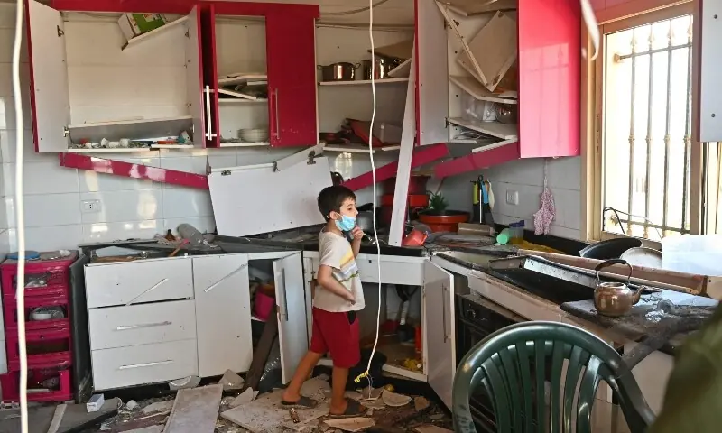 A Lebanese child stands inside the kitchen of the family home looking at the damage caused by Israeli military strikes, in the southern Lebanese village of Srifa on June 24, 2026. &mdash;AFP
