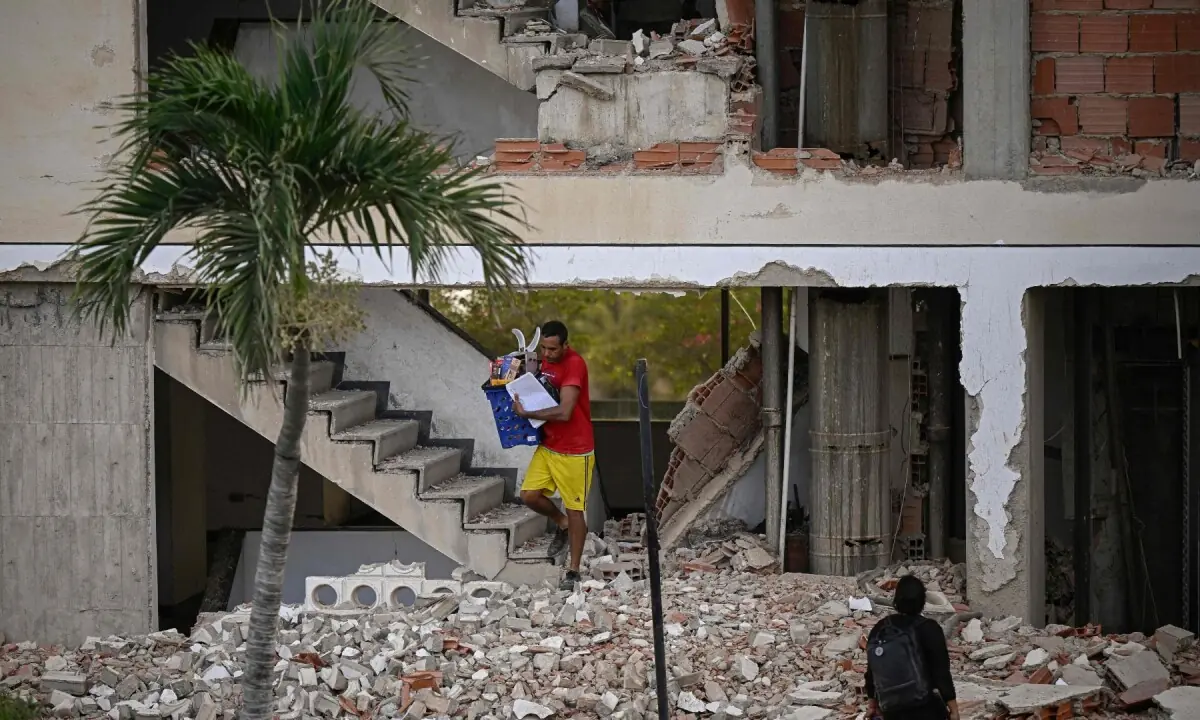 A man carries belongings out of a damaged building following an earthquake in Catia La Mar, La Guaira state, some 30km north-west of Caracas, on June 25, 2026. &mdash;AFP