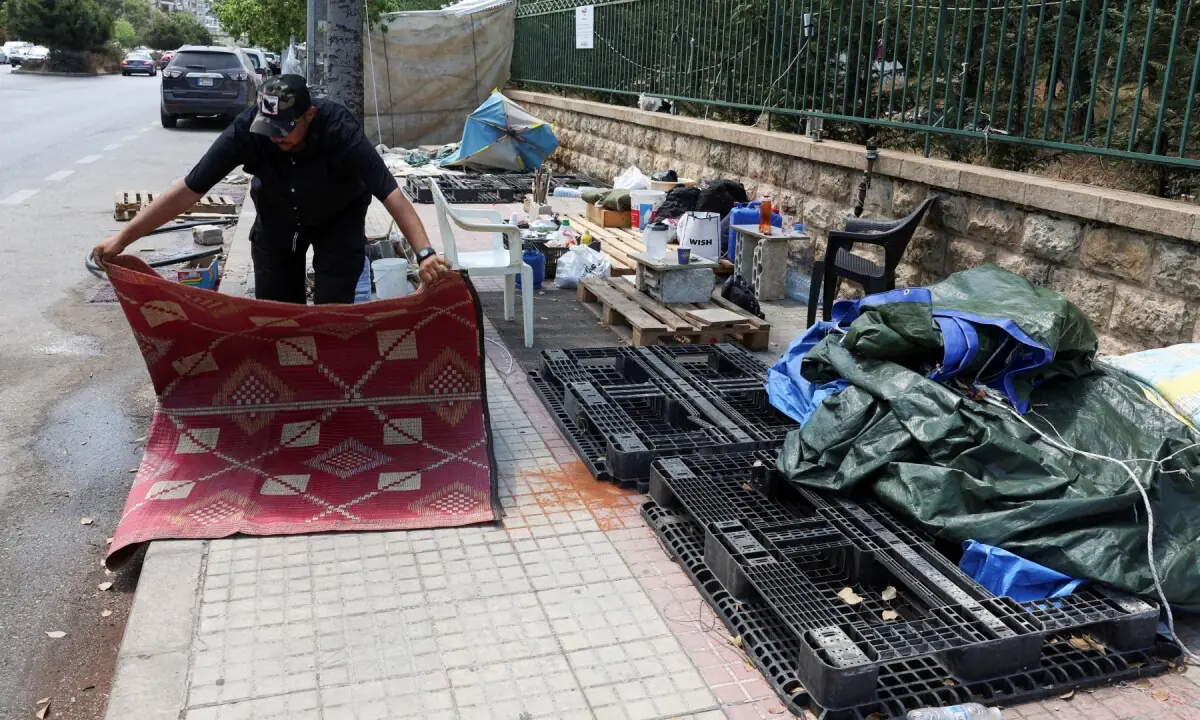 Alaa Kobeissy packs his belongings on a sidewalk in Beirut, where he and his family have been living in a tent, as he prepares to return home following an interim deal between the U.S. and Iran, in Beirut, Lebanon on June 24, 2026. &mdash;Reuters/File