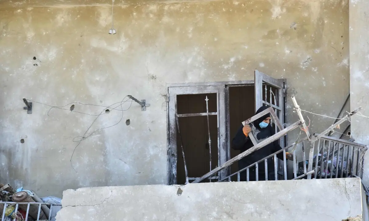 A Lebanese woman removes broken metal railing from her damaged house following Israeli military strikes, in the southern Lebanese village of Srifa on June 24, 2026. &mdash;AFP/File