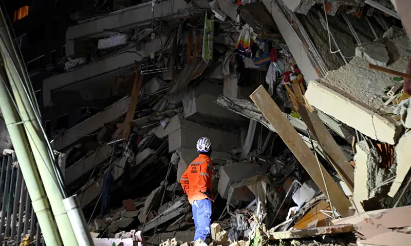  A rescuer looks at the rubble of a collapsed multi-storey building following the twin earthquakes.&mdash;AFP 