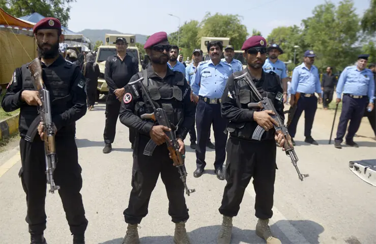  Security personnel stand alert as Muharram 9 procession passes through G-6 in Islamabad on Thursday. &mdash; Photo by Mohammad Asim 