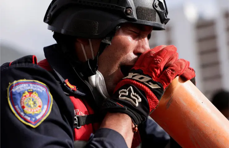  A firefighter screams through a tube to the people under the rubble of a collapsed building in La Guaira.&mdash;Reuters 