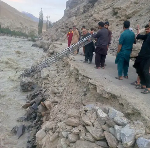 WORKERS pull out a power pylon that fell into the river in Ghanche district.—Photo by the writer