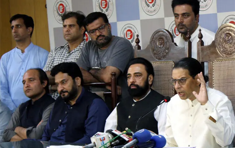FLANKED by local PTI leaders, Salman Akram Raja addresses a press conference in Lahore.—PPI