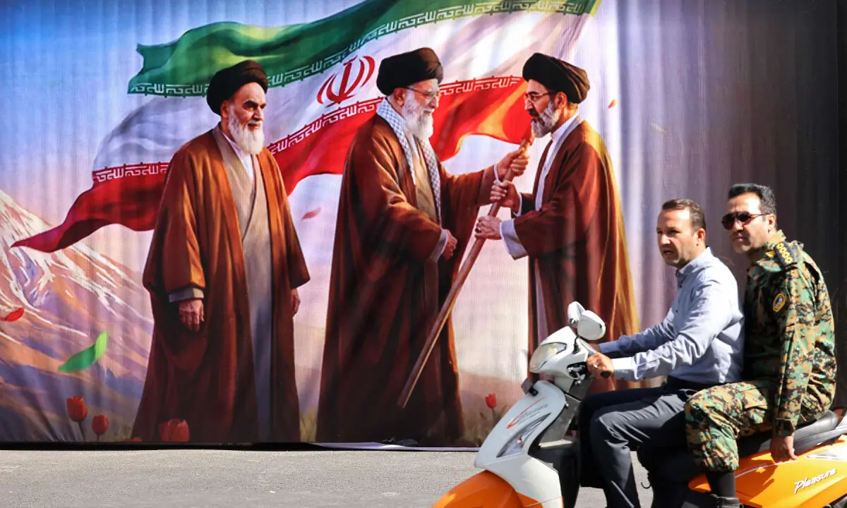 Men ride a scooter past a billboard featuring the images of the late founder of the Islamic Revolution supreme leader Ayatollah Ruhollah Khomeini (L), Iran’s assassinated supreme leader Ali Khamenei (C) and his son, the current supreme leader Mojtaba Khamenei, along the street in Tehran on July 3, 2026. — AFP