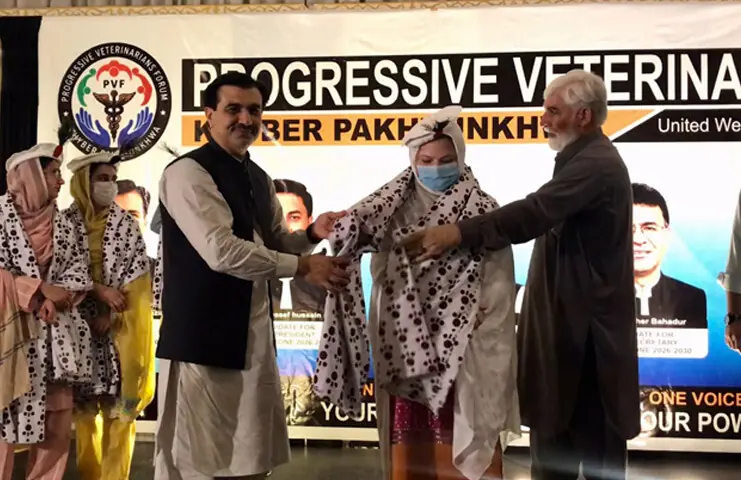 The traditional chail shawl is being presented to a woman veterinary doctor during a function in Swabi. — Dawn