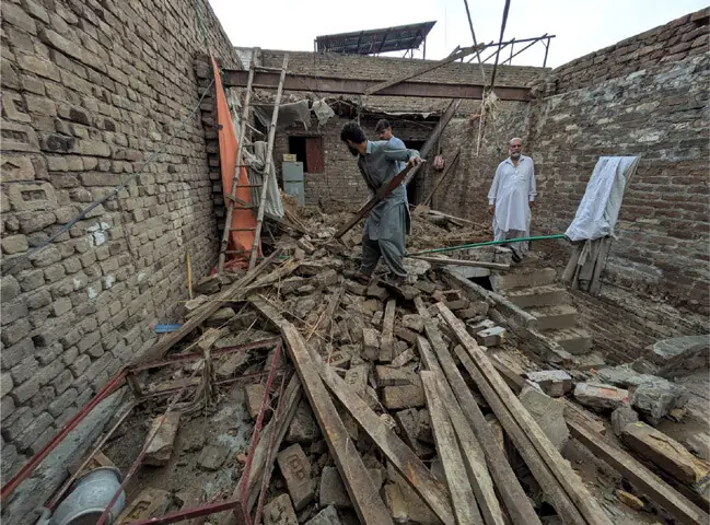  A man removes the debris after roof of a house collapsed due to rain in Pakha Ghulam village of Peshawar on Monday. &mdash; White Star 