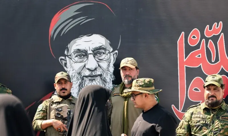 Security forces stand on a street in front of a banner depicting Iran&rsquo;s slain supreme leader Ali Khamenei in Najaf on July 7, 2026, a day before his funeral procession in the holy Iraqi city. &mdash;AFP