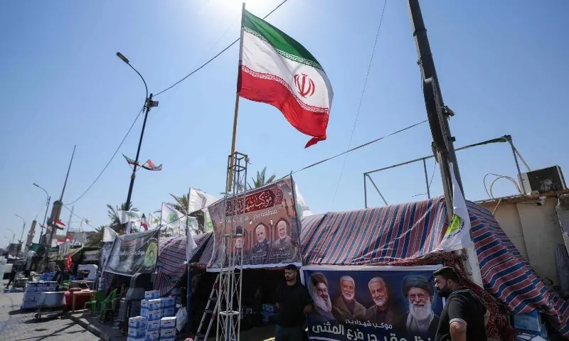 Iranian and Iraqi national flags flutter along a street in Najaf on July 7, 2026, a day before the funeral procession of Iran&rsquo;s slain supreme leader Ali Khamenei in the holy Iraqi city. &mdash;AFP