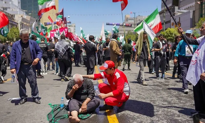 A medic tends to a man as mourner gather on a street ahead of the funeral procession of Iran&rsquo;s slain supreme leader Ali Khamenei and members of his family before his burial at the Shrine of Imam Reza, Iran&rsquo;s most revered place of worship, in Mashhad on July 9, 2026. &mdash;AFP