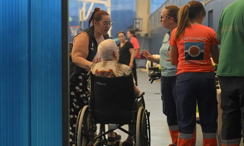A woman in a wheelchair is taken care of as evacuees from Bedar rest in the sports hall of Garrucha, near Los Gallardos, in Almeria, Spain on July 10, 2026 after a wildfire killed 11. —AFP
