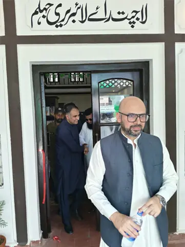 Jhelum Deputy Commissioner Mir Reza Ozgen and Minister of State Bilal Azhar Kayani leave the main hall of Lajpat Rai Library after its inauguration.