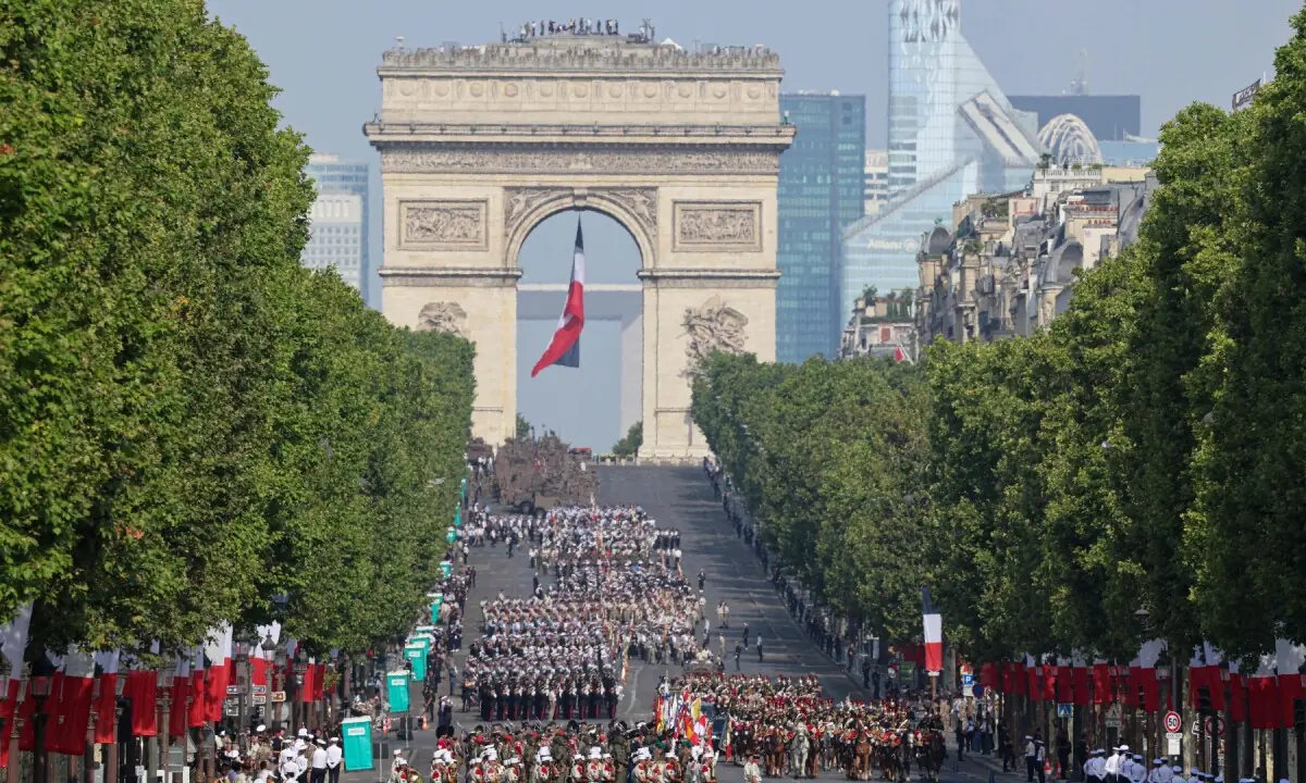 Troops march during the annual Bastille Day military parade as a national flag flutters under the Arc de Triomphe on the Champs-Elysees Avenue in Paris on July 14, 2026. &mdash;AFP