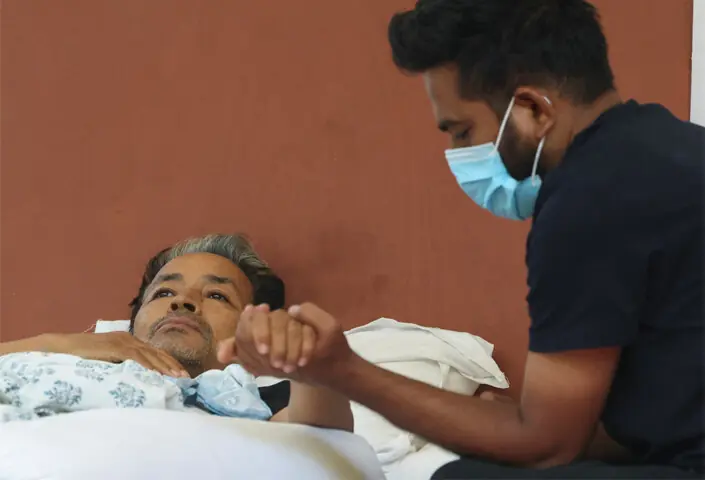 Abhijeet Dipke, head of the Cockroach Janta Party, holds Sonam Wangchuk’s hand while he rests on stage before being taken to a hospital in New Delhi.—Reuters