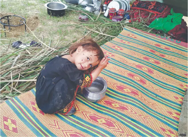 A Bakarwal child uses water to comb her hair at a nomadic settlement.