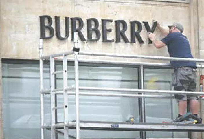 A workman replaces the Burberry letters outside its headquarters in central London. British luxury group Burberry announced last week that its first-quarter revenue had risen, driven by sales in the Americas and China, but said it remains vigilant regarding geopolitical and macroeconomic developments for the current year.—AFP