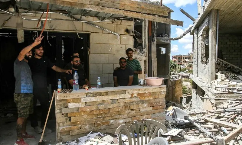 Men stand before a destroyed building in the village of Zawtar al-Gharbiyeh in southern Lebanon on July 26, 2026. &mdash;AFP