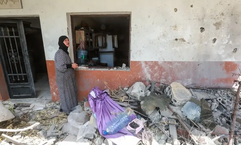 A woman stands near a damaged building in Zawtar al-Gharbiyeh, after the withdrawal of Israeli forces under a US-mediated plan, in southern Lebanon, July 26, 2026. &mdash;Reuters