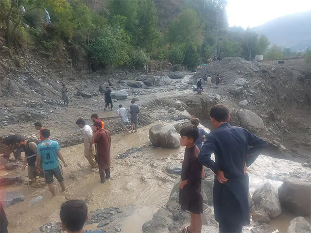 Villagers look for their belongings after the devastation caused by flash flood in Lower Chitral on Tuesday. — Dawn