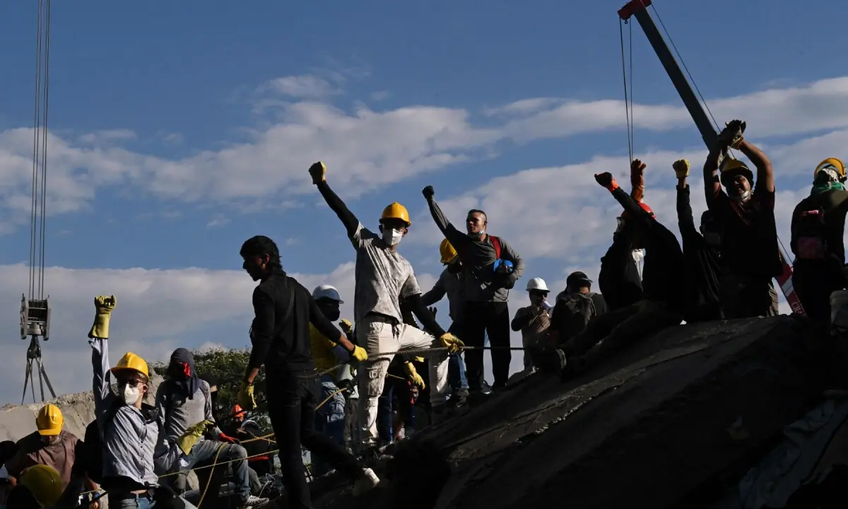 Volunteers ask for silence with their fist up as they search for survivors amid the rubble of a collapsed building after an earthquake in Cali, Colombia on August 11, 2026. —AFP/File