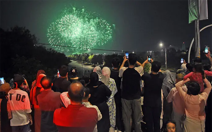 People watch fireworks at Zero-Point bridge during Independence Day ceremony at Yadgar-i-Fatah in Islamabad on Thursday night. — Online