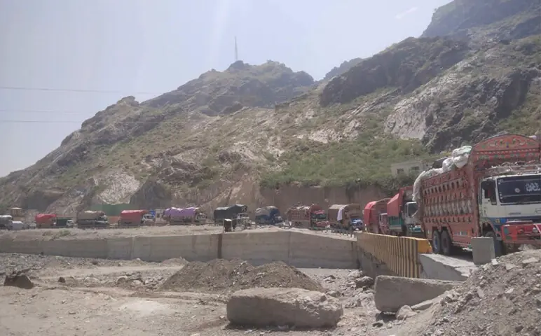  Vehicles taking Afghan families back to Afghanistan wait in a long queue near Torkham border before being examined by the customs authorities. &mdash; Dawn 