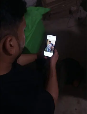   Muhammad Zafar looks at a photo of his daughter Abiha on his cell phone. Abiha died on June 27, 2026, while Zafar still awaits the result of a specialised genetic test needed to determine what caused her death | Courtesy Muhammad Zafar 