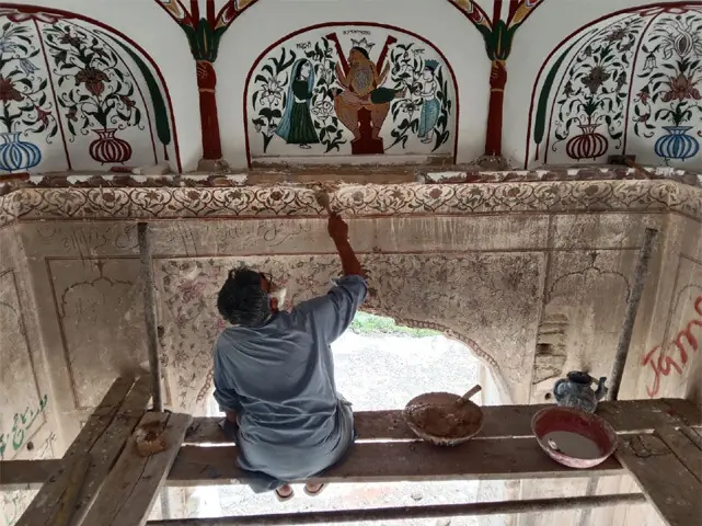 An artist gives the finishing touches to artwork inside the temple.