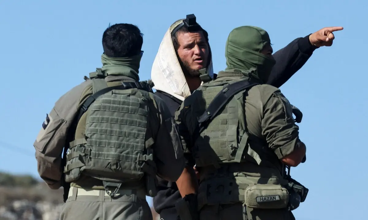 Israeli soldiers speak to an Israeli settler who entered Palestinian-American Loui Ridi&rsquo;s property, in Qusra, Israeli-occupied West Bank on August 18, 2026. &mdash;Reuters